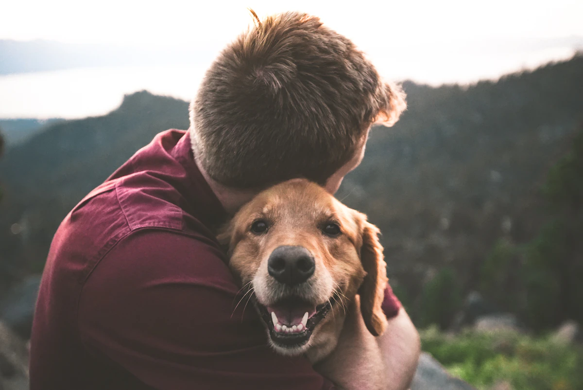 Un homme retrouve son chien et le serre joyeusement dans ses bras.